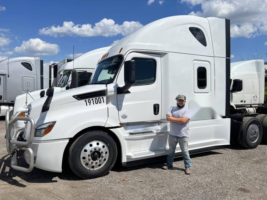 Eastwind driver standing next to a late-model Freightliner Cascadia