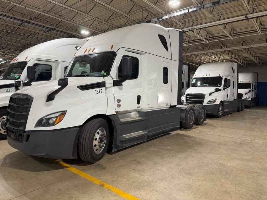 Row of white semi trucks staged in the warehouse